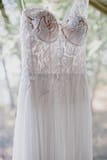 Lace wedding dress hanging from tree by Nectar and Root, Vermont wedding florist at shelburne coach barn in shelburne, vermont.