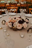 Low lush fall centerpiece of September garden roses and dahlias with a gold vase in a blush, burgundy and rust color palette for an outdoor reception tent by Nectar and Root, Vermont wedding florist at Edson Hill in Stowe, Vermont.