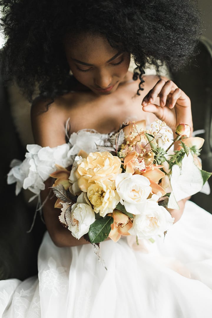 A simple spring peach, blush, yellow, and rust June bridal bouquet of garden roses, foxglove and orchids by Nectar and Root, a Vermont wedding florist at Foxfire Mountain House in the Catskills, New York.