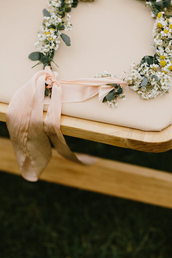 Green, white and blush flower crown on chair by Nectar and Root, Vermont wedding florist at Shelburne Coach Barn in Shelburne, Vermont.