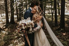 Bride and groom at romantic outdoor fall private estate holding a modern September bridal bouquet of garden roses, hanging amaranth, sweet peas, dahlias, cosmos and zinnias by Nectar and Root, Vermont wedding florist at Edson Hill in Stowe, Vermont.