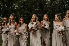 Bride and bridesmaids at romantic fall outdoor private estate holding modern September bridal and bridesmaids' bouquets of garden roses, hanging amaranth, sweet peas, dahlias, cosmos and zinnias in a warm neutrals palette by Nectar and Root, Vermont wedding florist at Edson Hill in Stowe, Vermont.