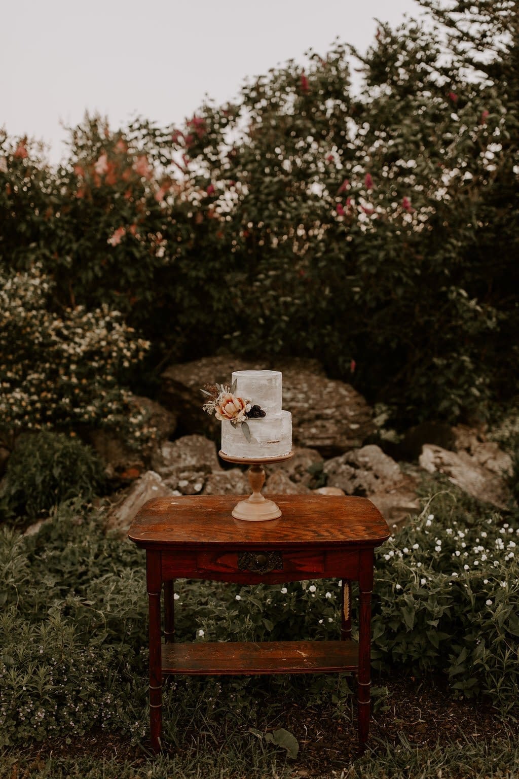 Elopement blush and peach wedding cake flowers on rustic farm table by Nectar and Root, Vermont wedding florist at a backyard wedding in Vermont.