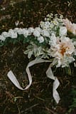 A simple cafe au lait dahlia bridal bouquet with flowering branches and flowing hand dyed silk ribbon by Nectar and Root, Vermont wedding florist at Shelburne Coach Barn in Shelburne, Vermont.