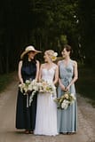 Bride standing with bridesmaids in blue dresses holding bouquets by Nectar and Root, Vermont wedding florist at Shelburne Coach Barn in Shelburne, Vermont.
