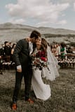 Elopement couple holding boho outdoor summer bridal bouquet of June summer flowers by Nectar and Root, Vermont wedding florist at a backyard wedding in Vermont.