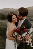 Outdoor micro wedding bride and groom with mountain views holding a summer bridal bouquet by Nectar and Root, Vermont wedding florist at a backyard wedding in Vermont.