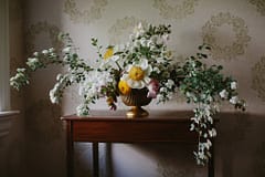 Centerpiece of peonies, ranunculus, hellebores and spirea by Nectar and Root, Vermont wedding florist at Shelburne Coach Barn in Shelburne, Vermont.