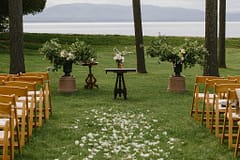 Ceremony decorations of white aisle petals and urns with flowering branchesby Nectar and Root, Vermont wedding florist at Shelburne Coach Barn in Shelburne, Vermont.
