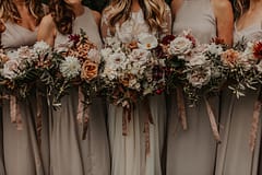 Bride and bridesmaids at romantic fall outdoor private estate holding modern September bridal and bridesmaids' bouquets of garden roses, hanging amaranth, sweet peas, dahlias, cosmos and zinnias in a warm neutrals palette by Nectar and Root, Vermont wedding florist at Edson Hill in Stowe, Vermont.