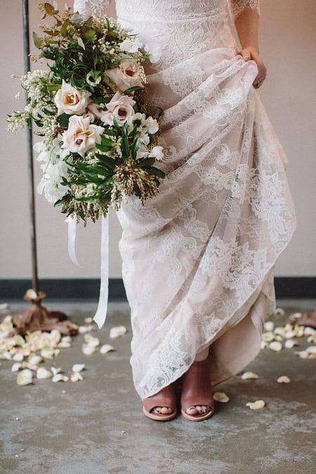 An elopement bride standing with a lush spring classic bridal bouquet of May garden roses, anemones, and sweet peas by Nectar and Root, Vermont wedding florist.