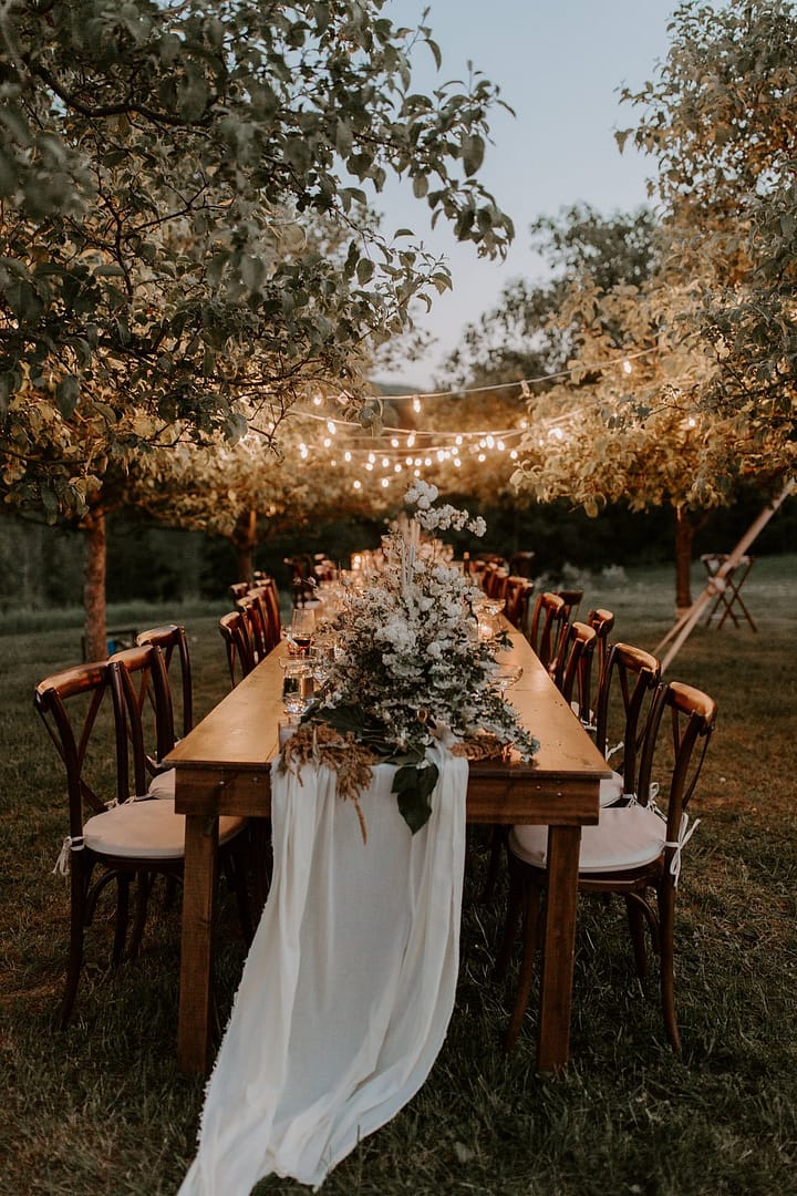 Outdoor elopement farm table flower and greenery runner reception centerpiece by Nectar and Root, Vermont wedding florist at a backyard wedding in Vermont.